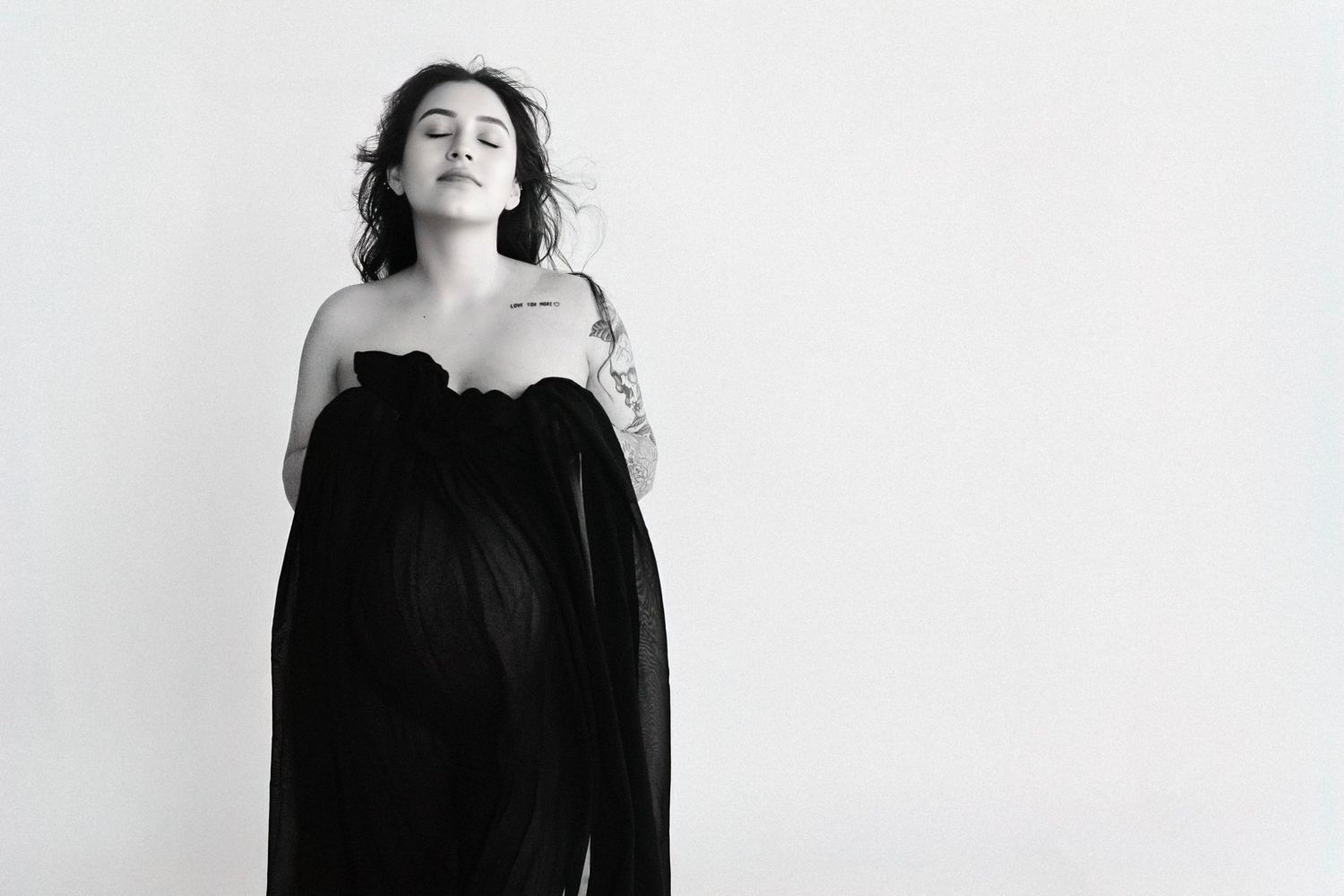 Black and white portrait series showing the same person in four different poses wearing dark clothing against a light background.