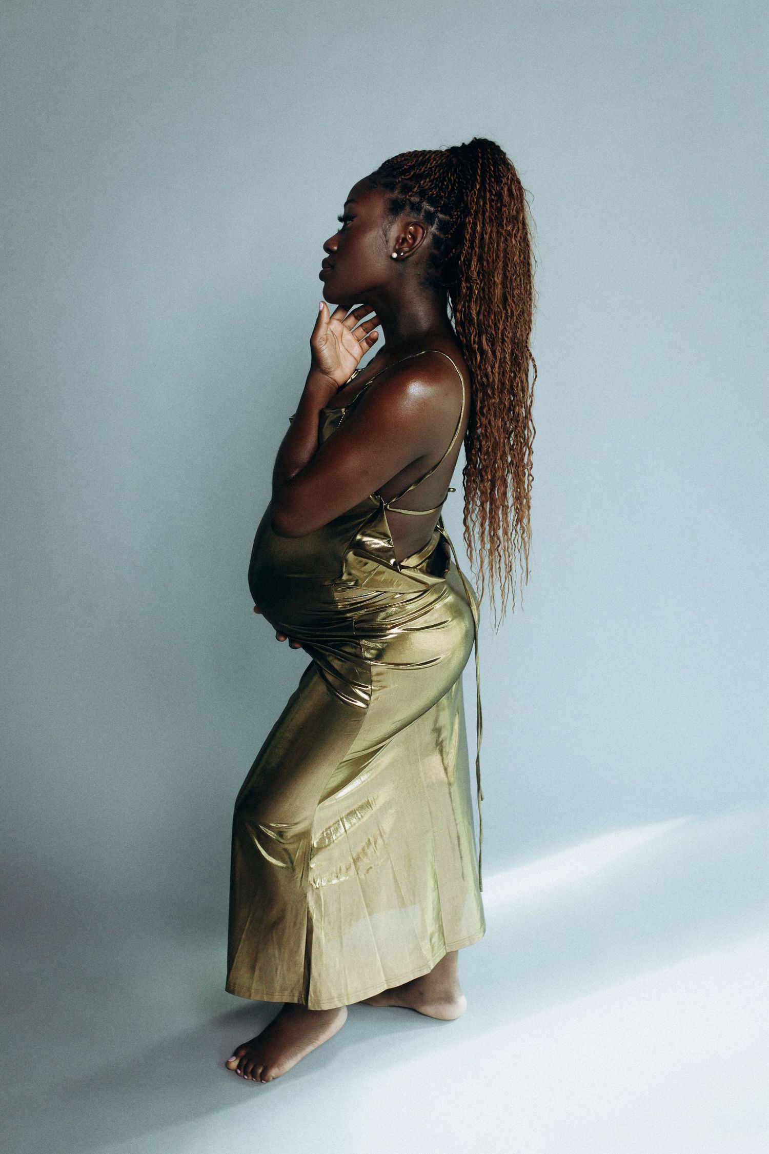 Artistic fashion photo series showing model in gold dress against white backdrop from different dramatic angles.