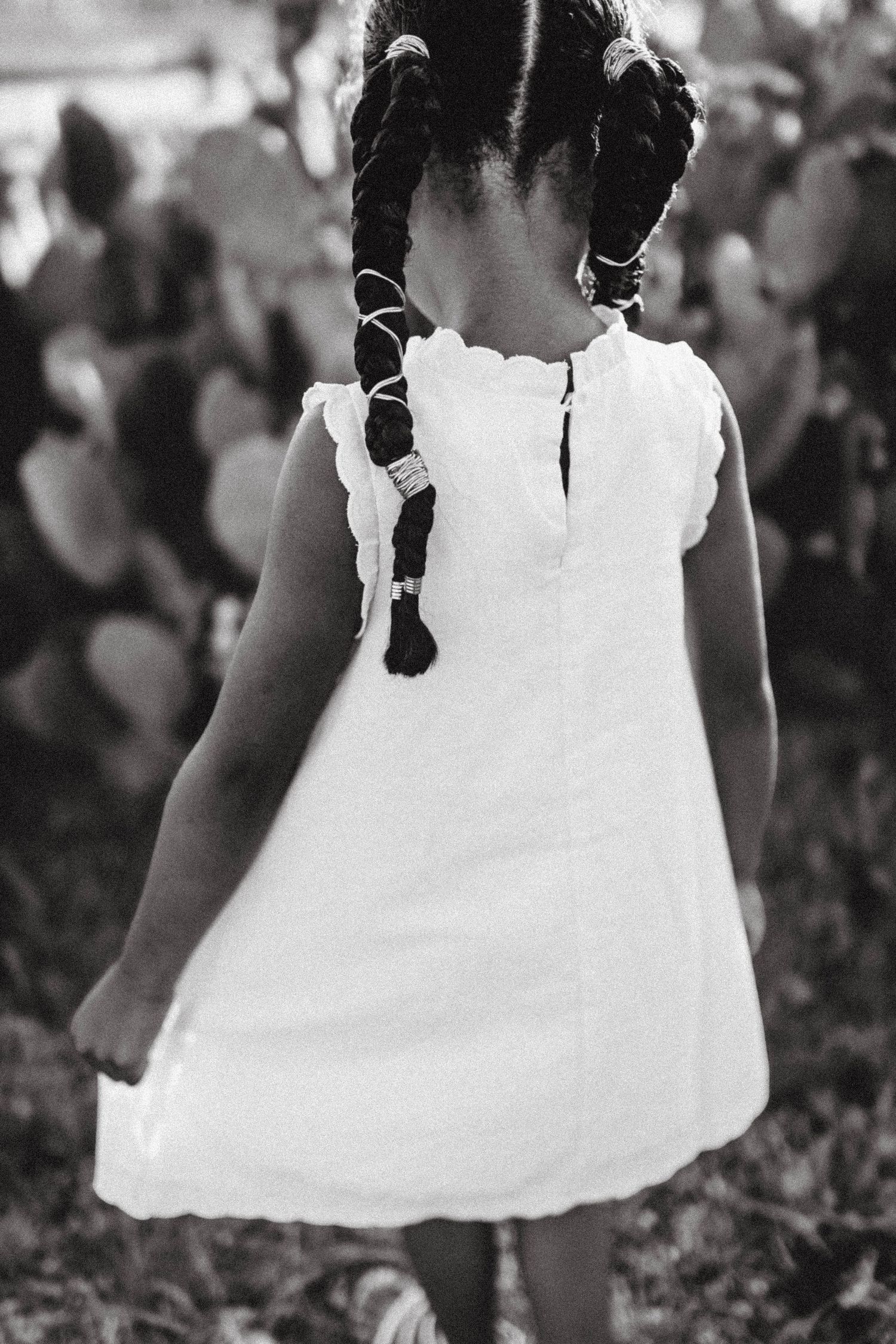 Black and white image series showing details of white dress and braided hair.