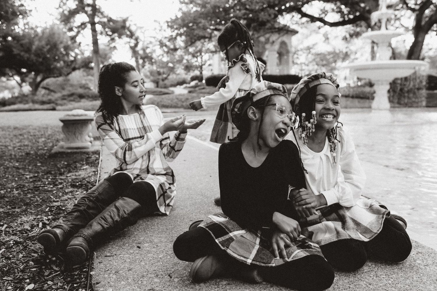 Black and white candid portrait of children laughing outdoors.