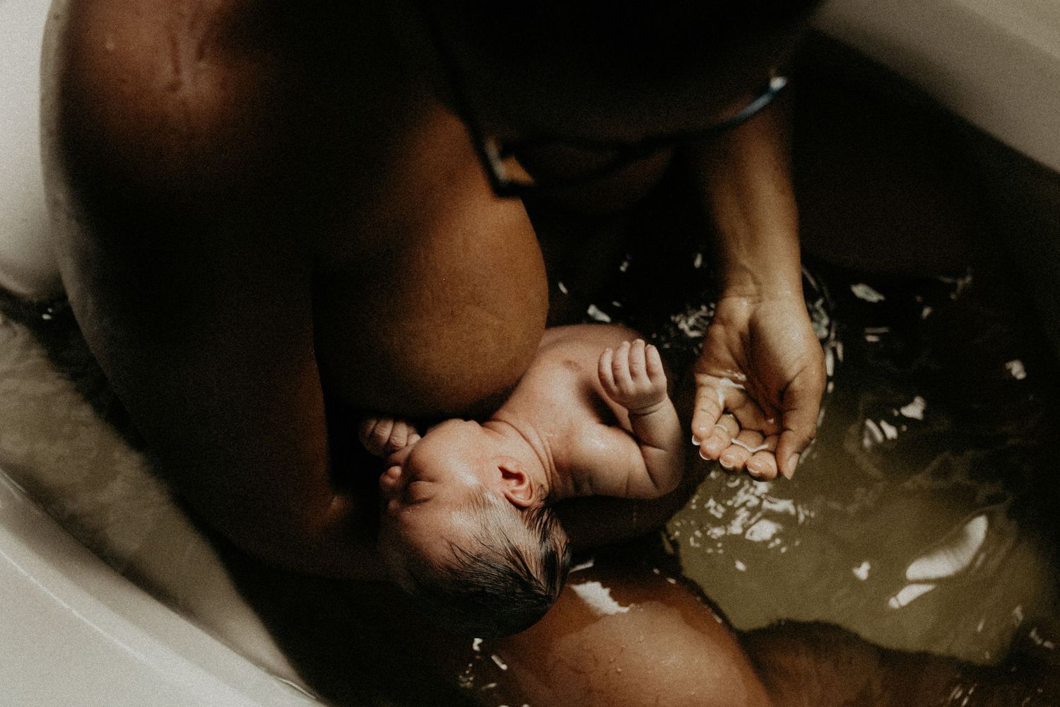 Moody bath photography with dramatic lighting and water reflections.