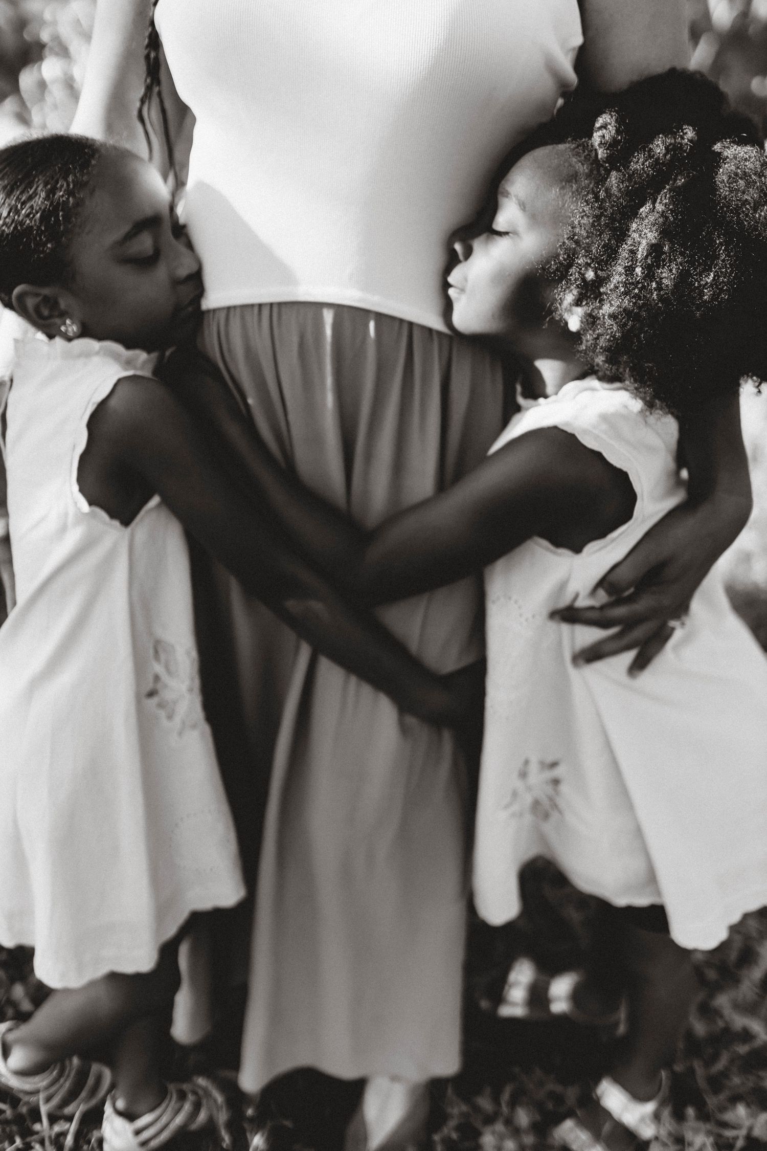 A series of intimate black and white photographs showing embracing figures in white clothing.
