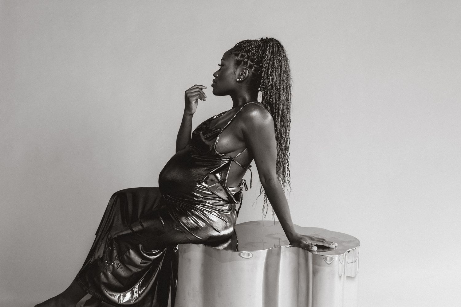 Black and white photo series showing intimate artistic poses of a woman in a dress against a minimalist background.