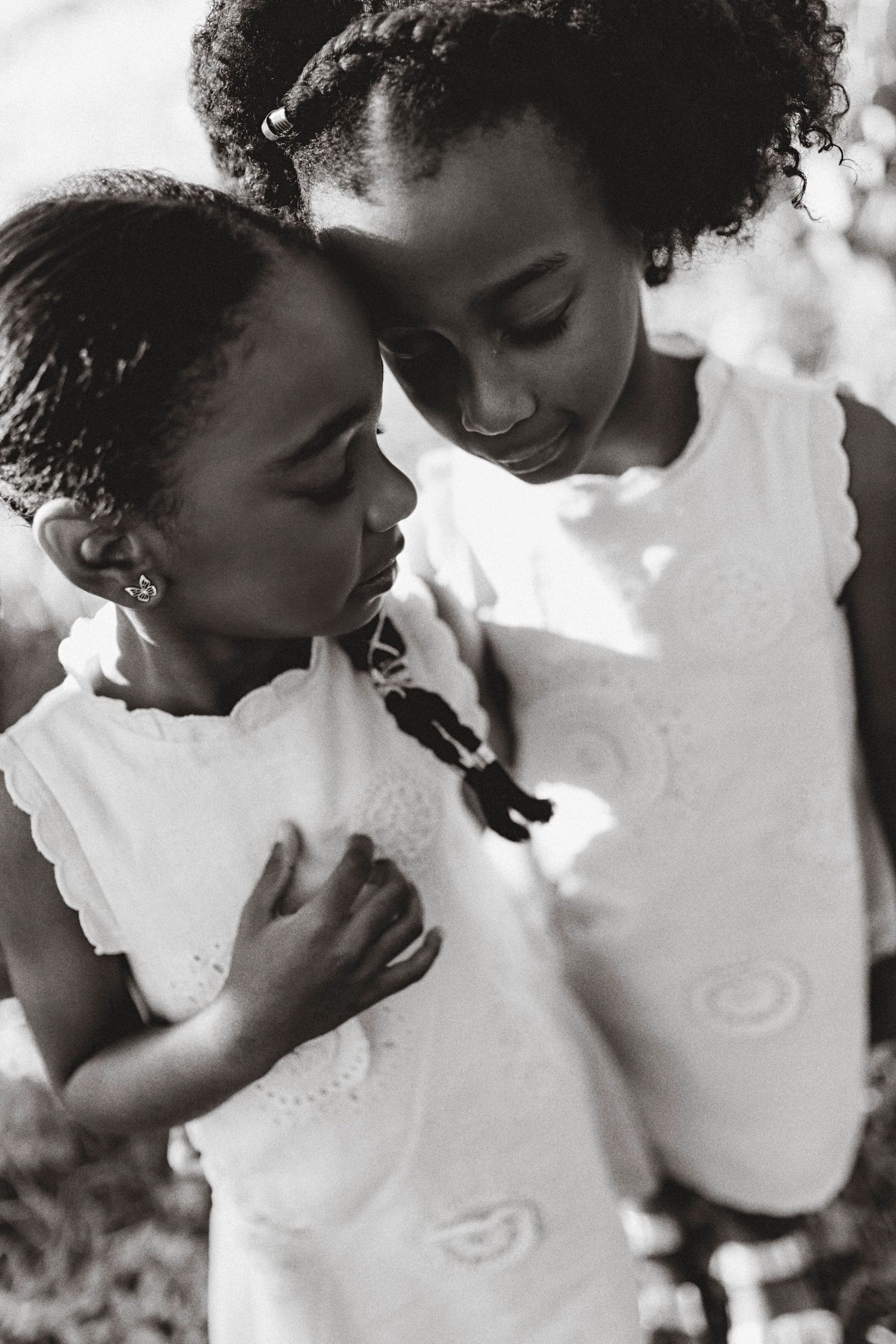 Sweet black and white portrait of two children in white dresses.