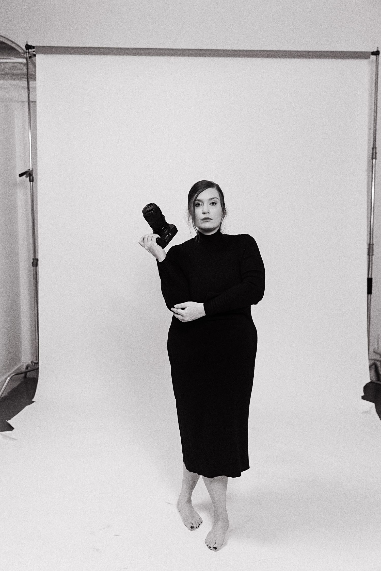 Minimalist studio portraits against white background showing dramatic poses in black clothing.