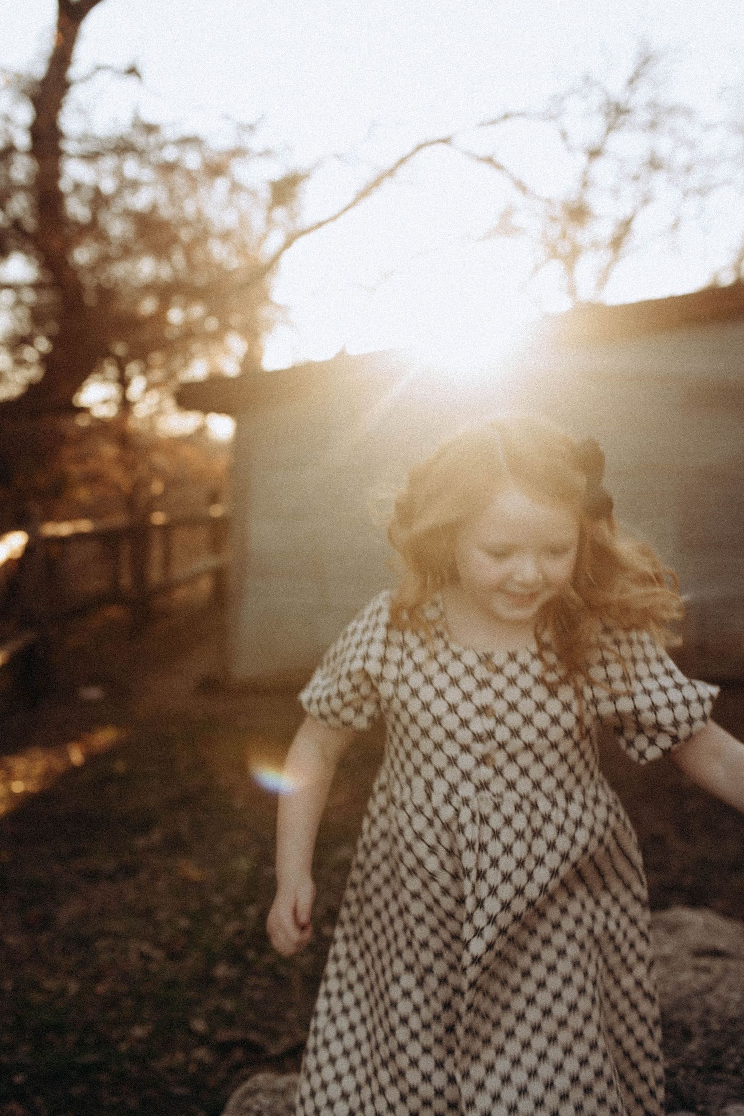 Golden hour portrait series with natural sunlight and checkered dress pattern.