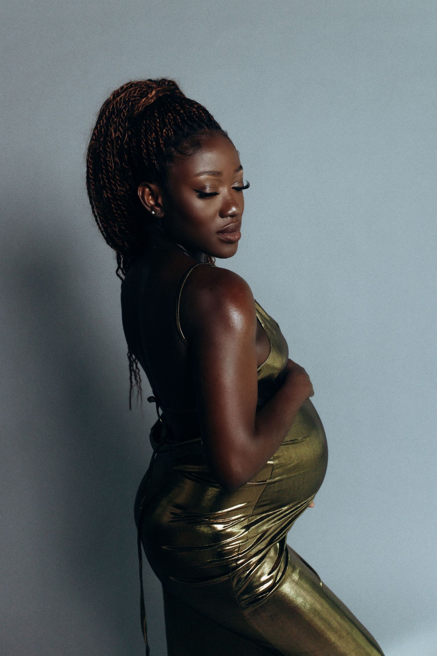 A series of profile shots showing a person in a metallic gold dress posing against a gray background.
