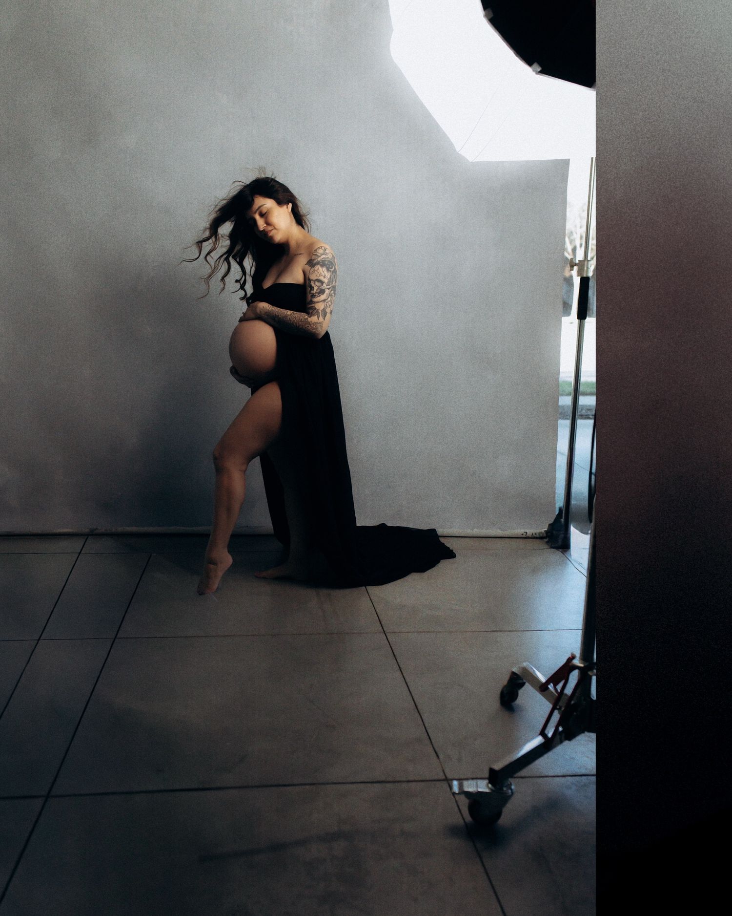 Artistic dance photography series showing silhouetted figure in black dress against stark white wall in dramatic poses.
