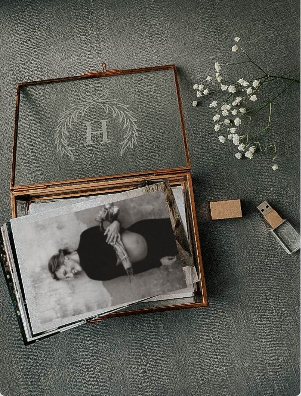 Vintage-style maternity photos in wooden box with monogram H and baby's breath flowers.