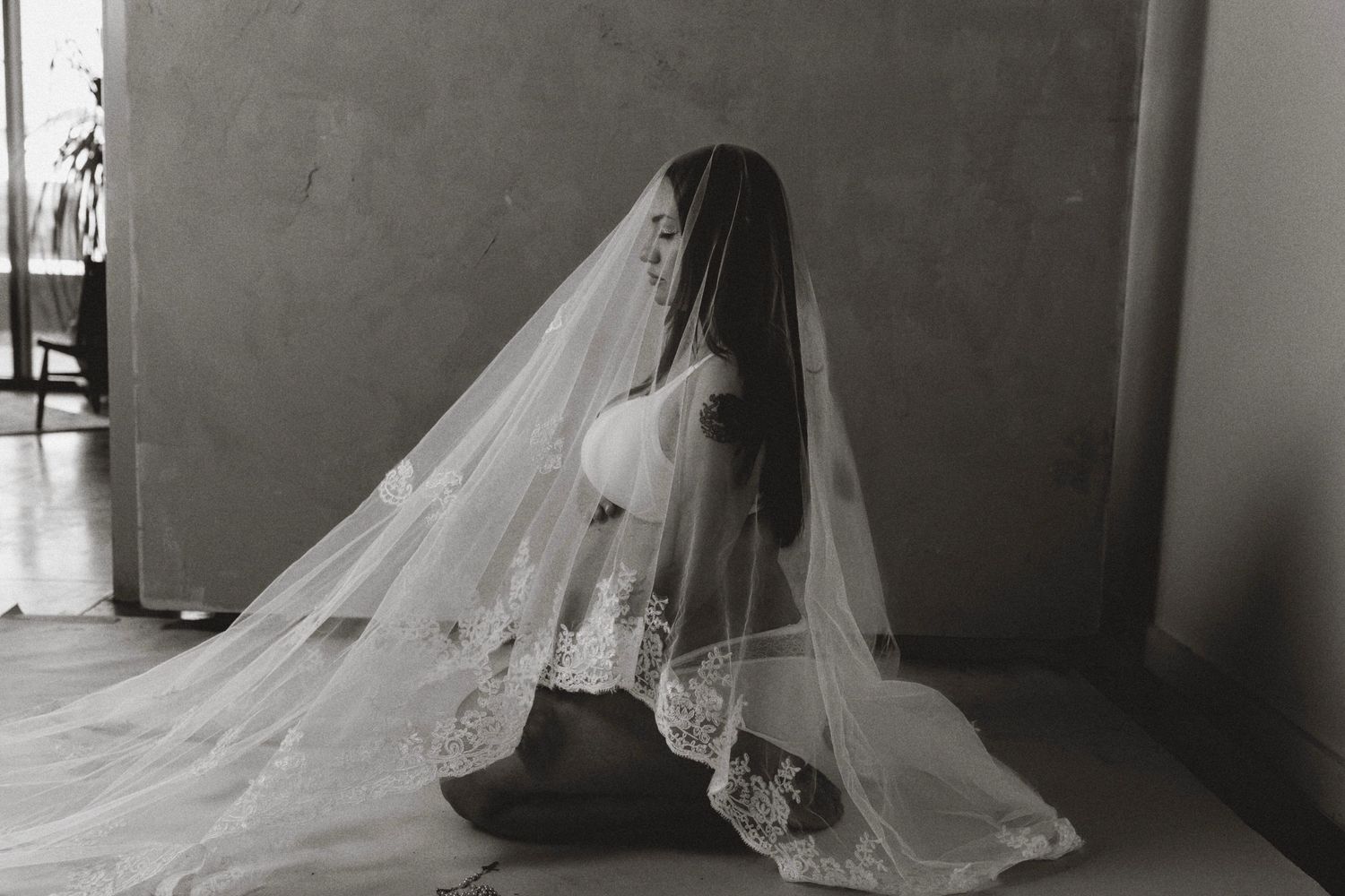 Series of black and white photos showing a bride in a flowing veil against a minimalist background.