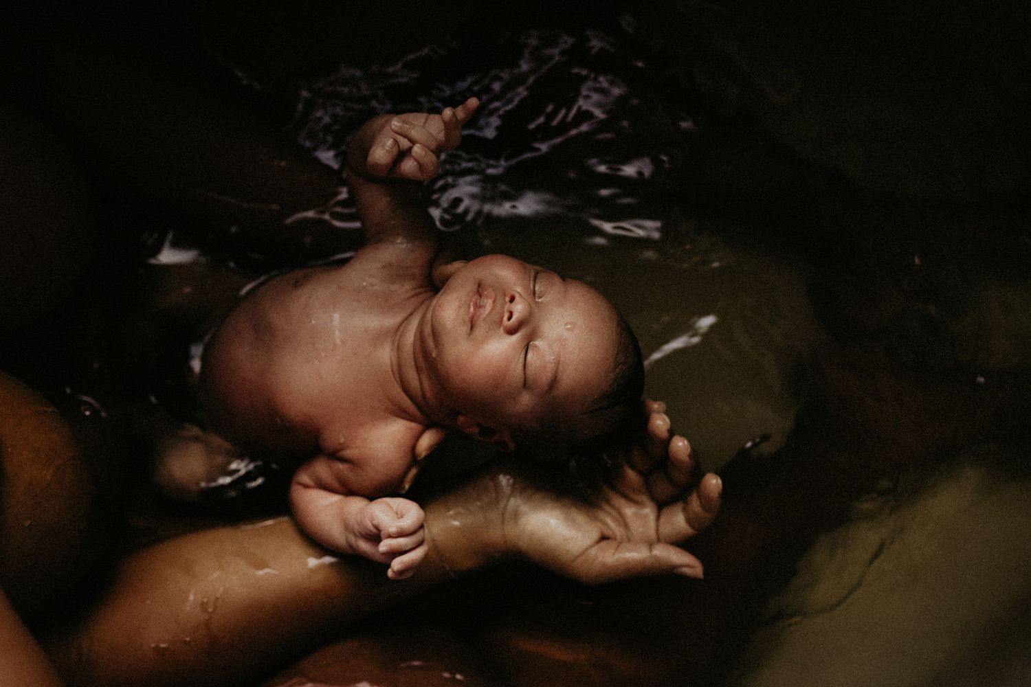 Artistic black and white photography capturing intimate bathing moments in dark lighting.
