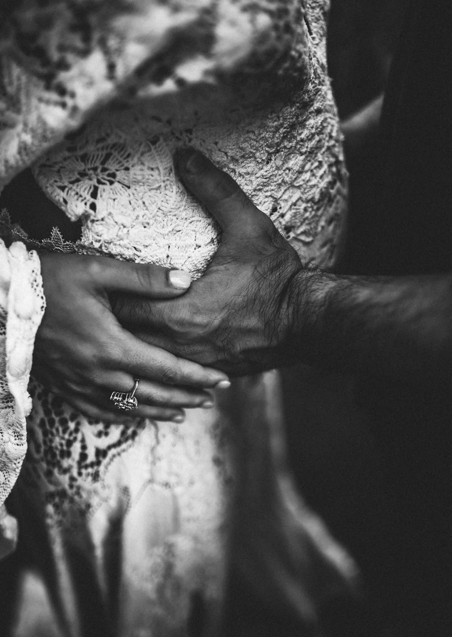Abstract black and white close-up of hands against textured surface.