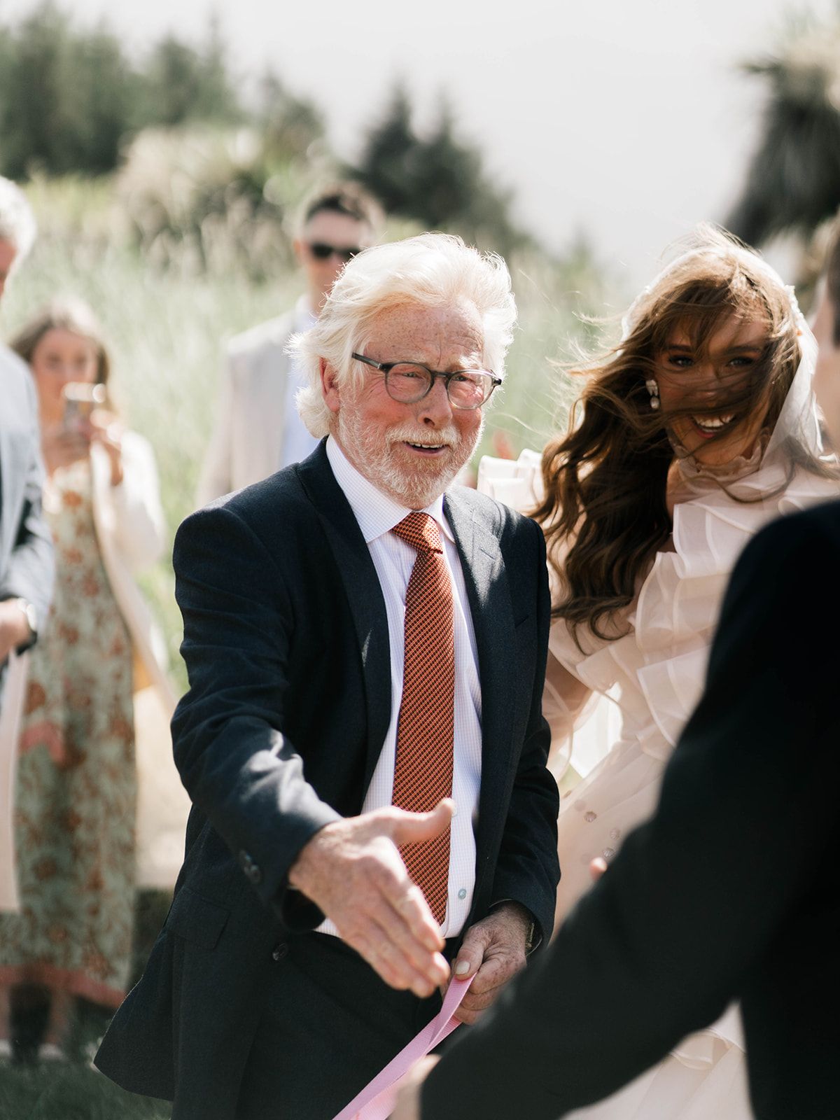 Wedding guests share emotional moments during an outdoor ceremony.