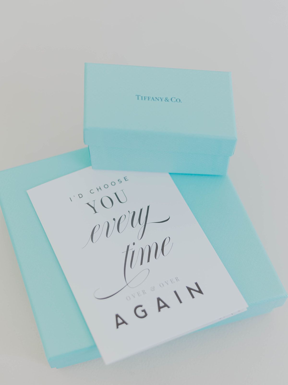A Tiffany & Co gift box with a white card that reads 'I choose you every time again' in elegant script lettering.