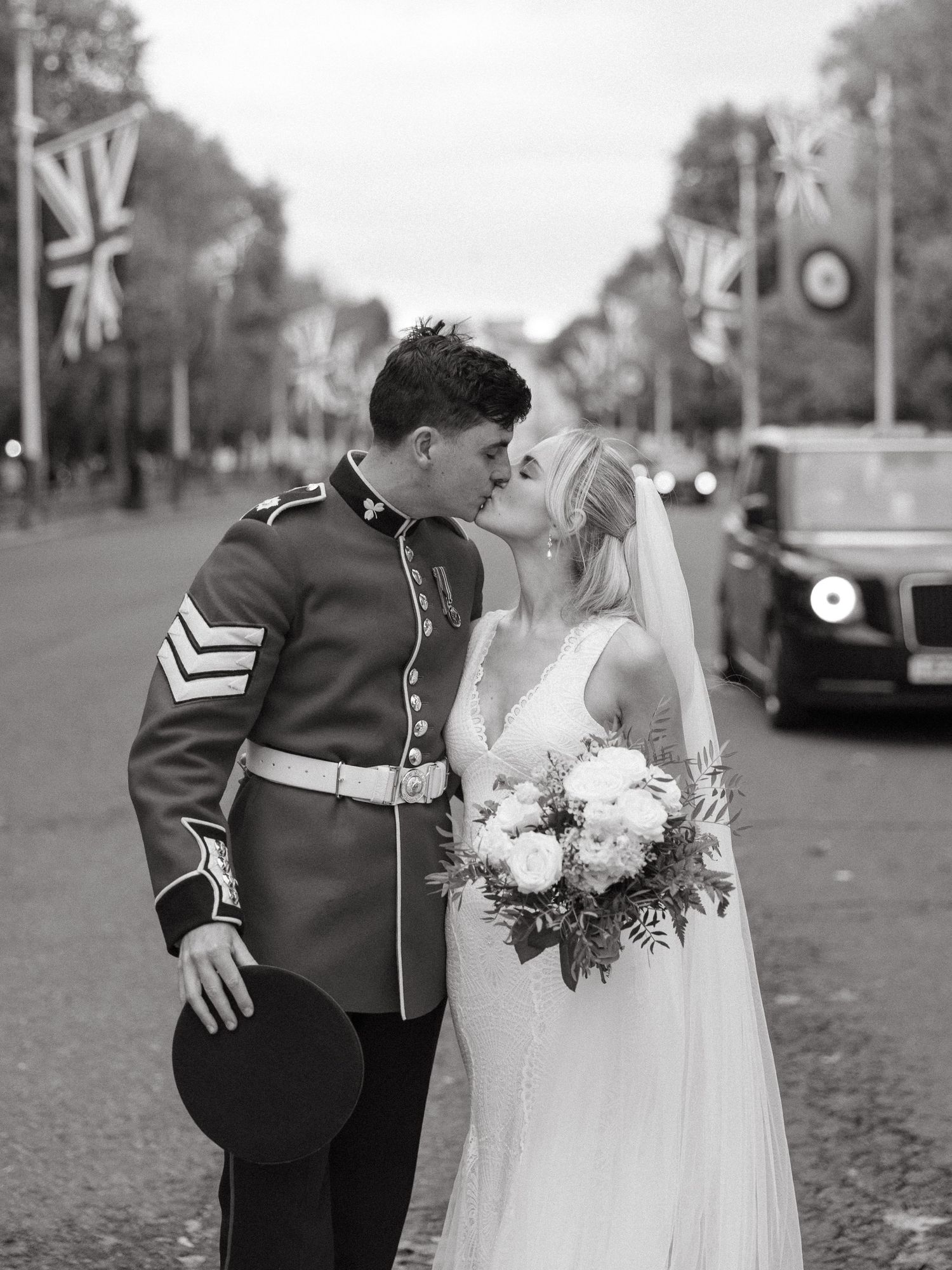 A black and white wedding photo showing details of a bride in an off-shoulder dress and groom in classic tuxedo with bow tie.