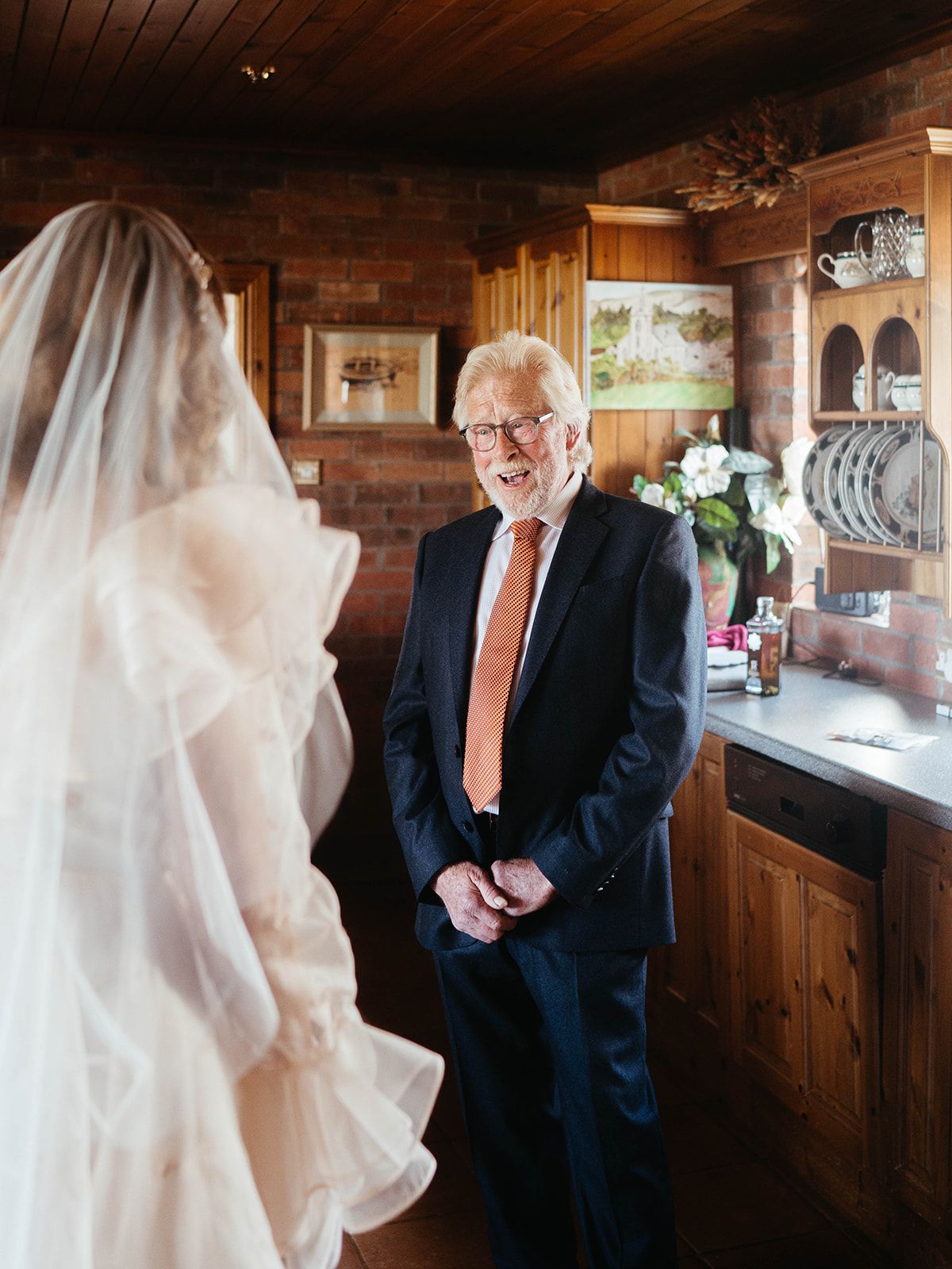 An emotional wedding moment shared in a rustic wooden interior space.