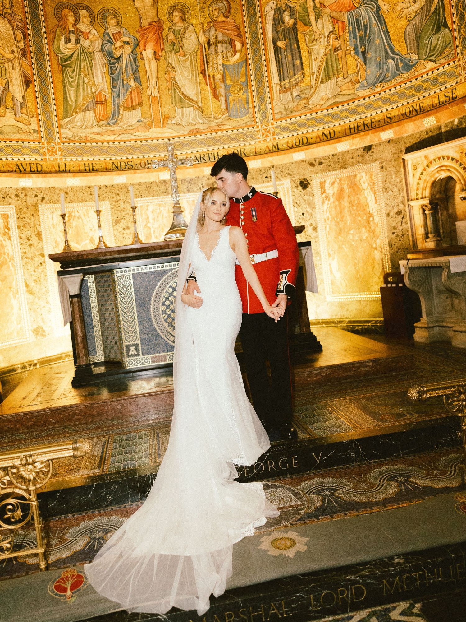 A couple dancing together in a beautifully lit historic venue with ornate murals and frescoes adorning the walls and ceiling.