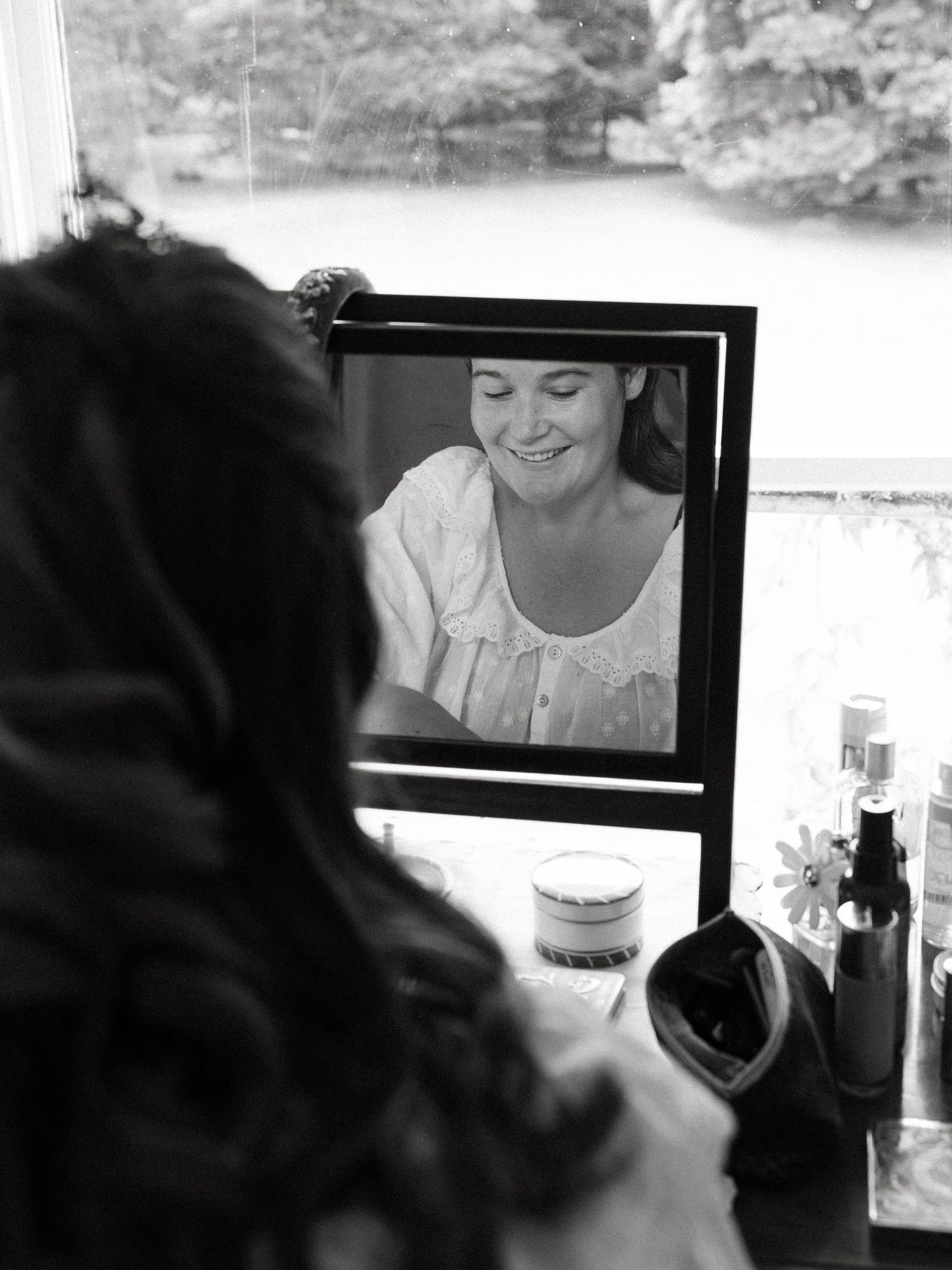 Black and white wedding photo montage showing intimate moments during bridal preparation in mirror reflections.