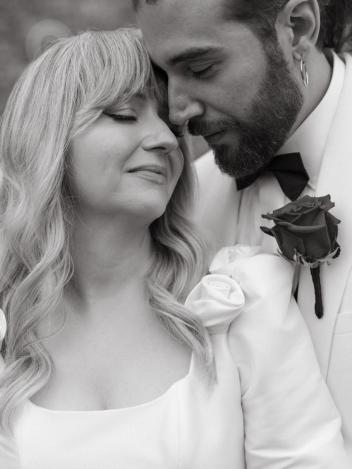 A romantic black and white photo series of a couple in white clothing sharing intimate moments together.