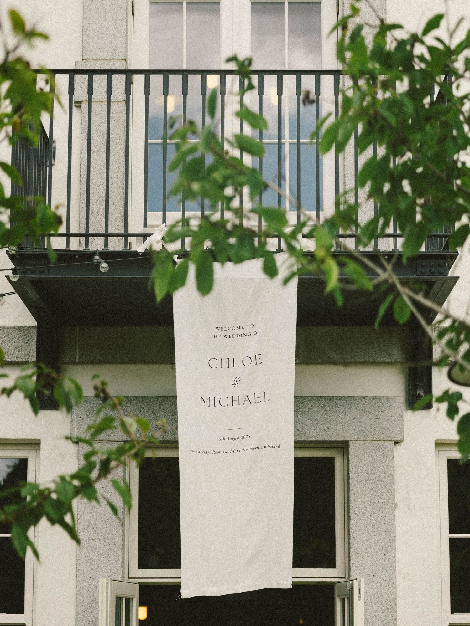 Wedding venue exterior with elegant name cards hanging between windows.