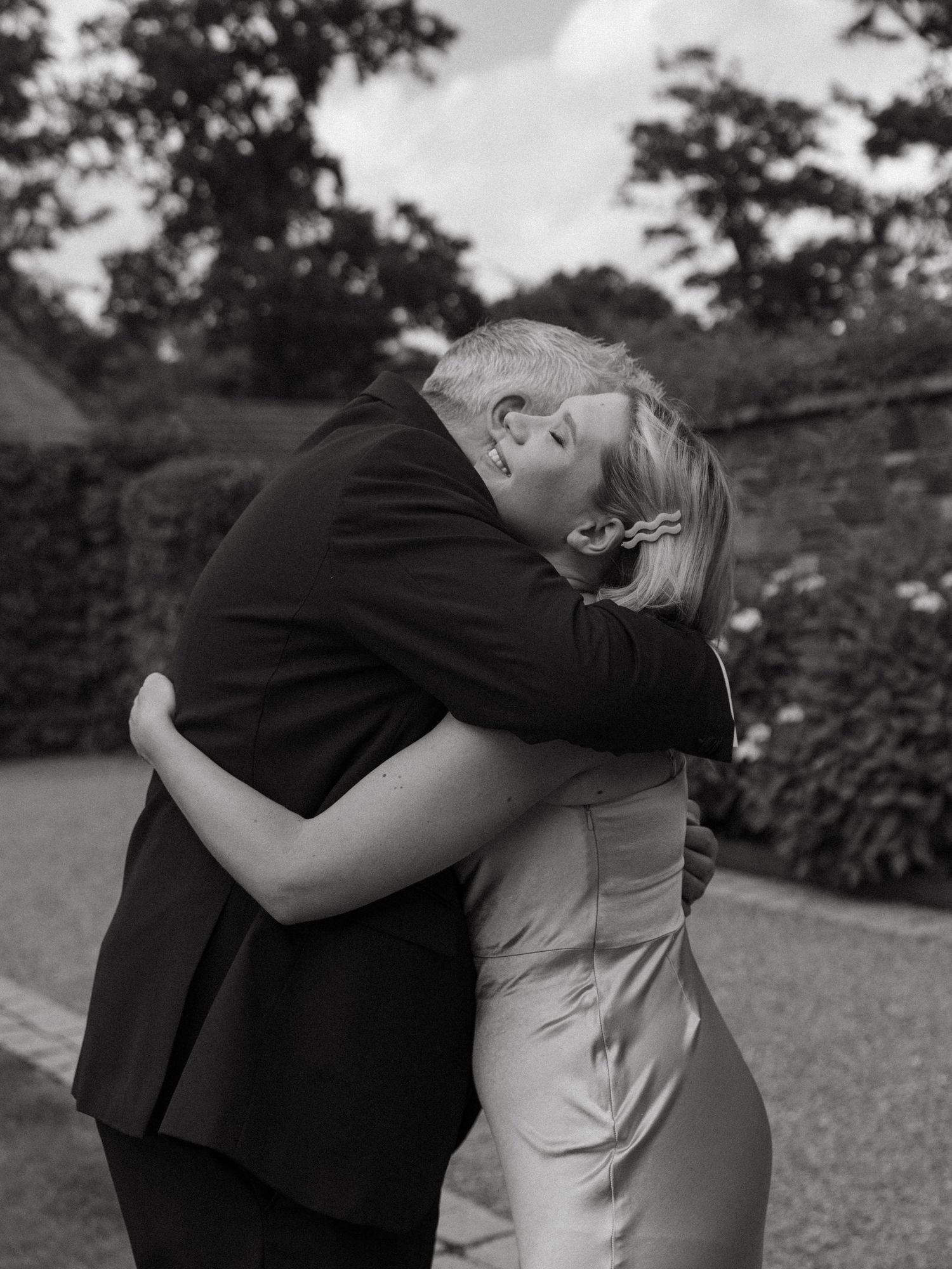 Intimate black and white portrait of a couple embracing outdoors during their wedding.