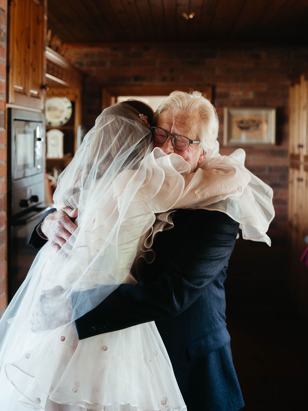 A touching embrace shared during a wedding day in a cozy wooden interior.