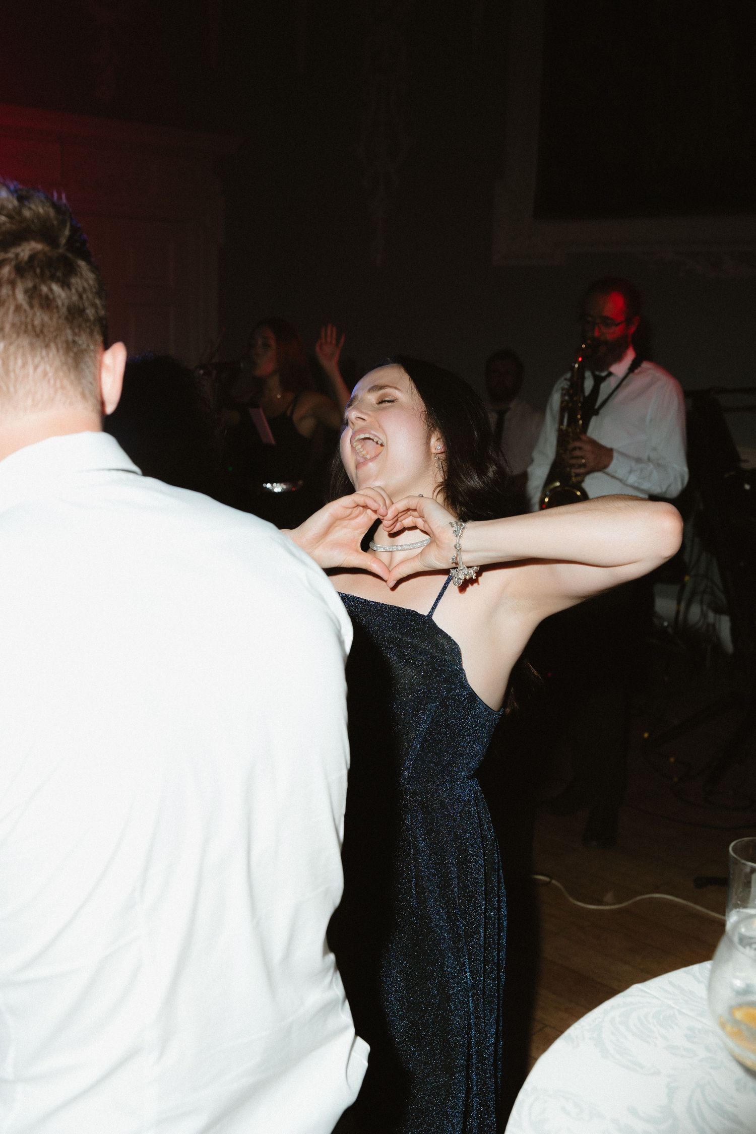 Party guests dancing and celebrating on a dimly lit dance floor.