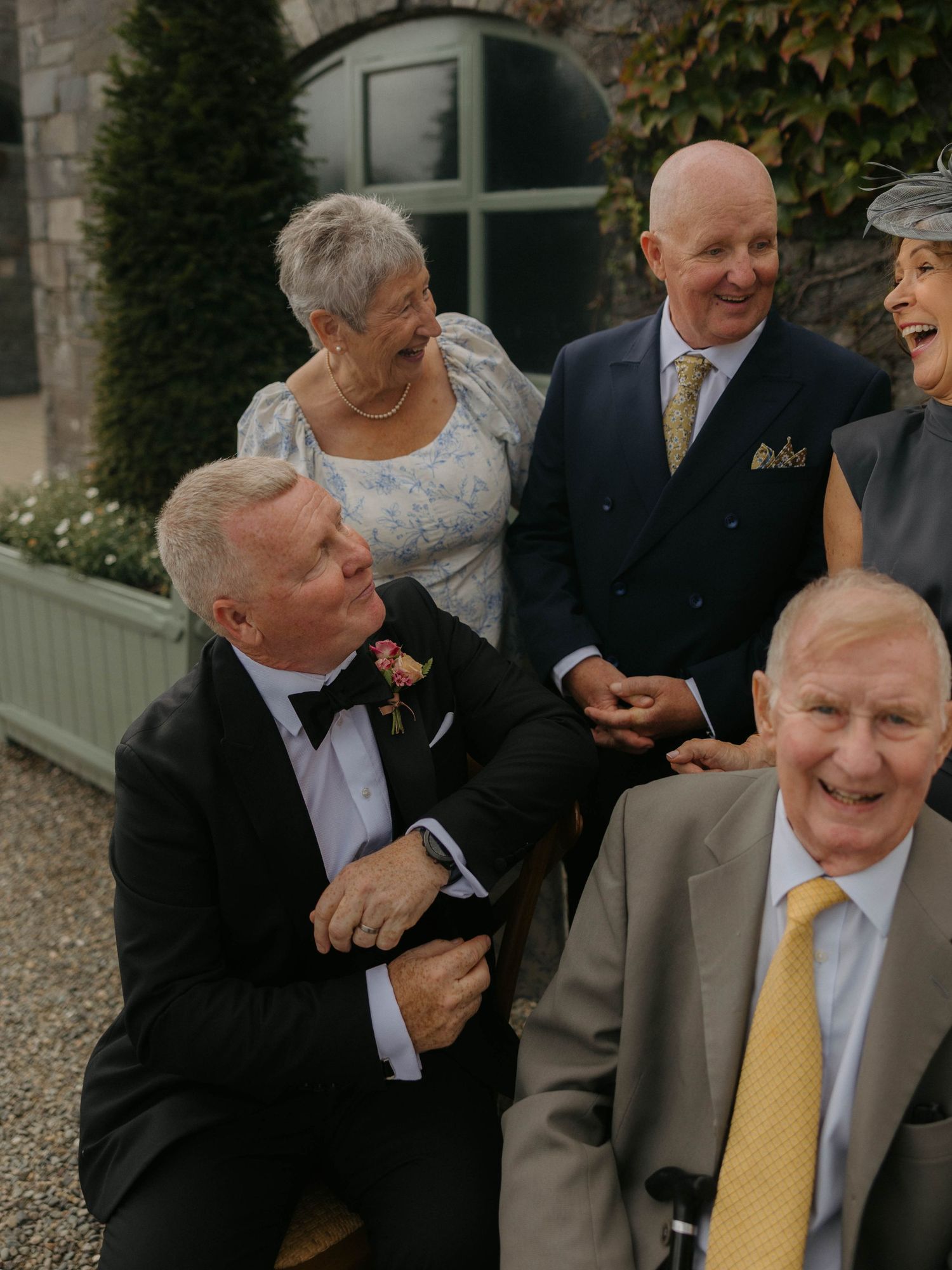 Candid laughter shared between wedding guests during outdoor reception.