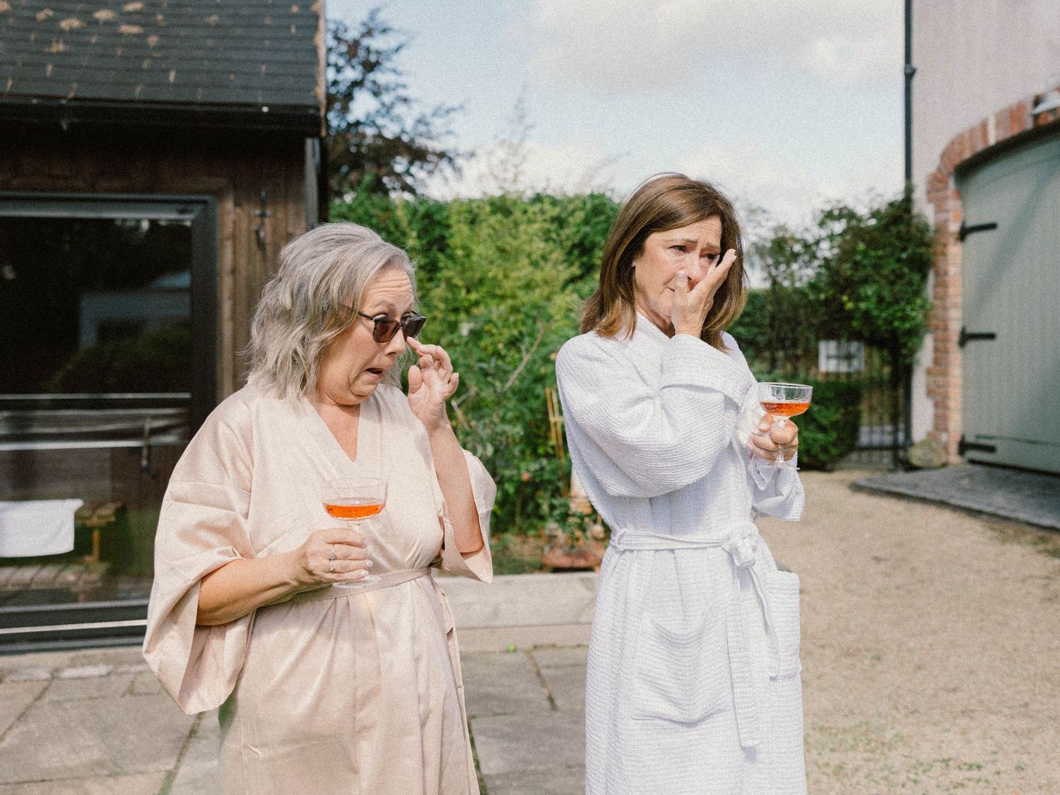 Wedding guests enjoying drinks and celebrating outdoors on a sunny day.