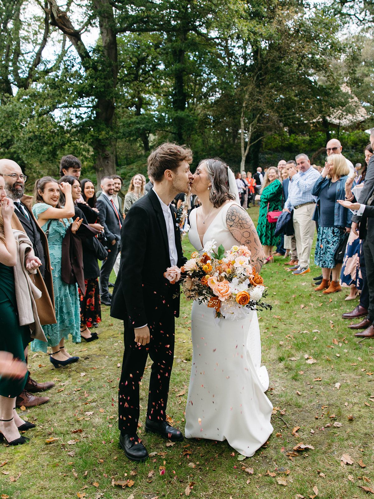 A joyful outdoor wedding ceremony in Green Mountains Vermont as couple shares a tender moment surrounded by guests.