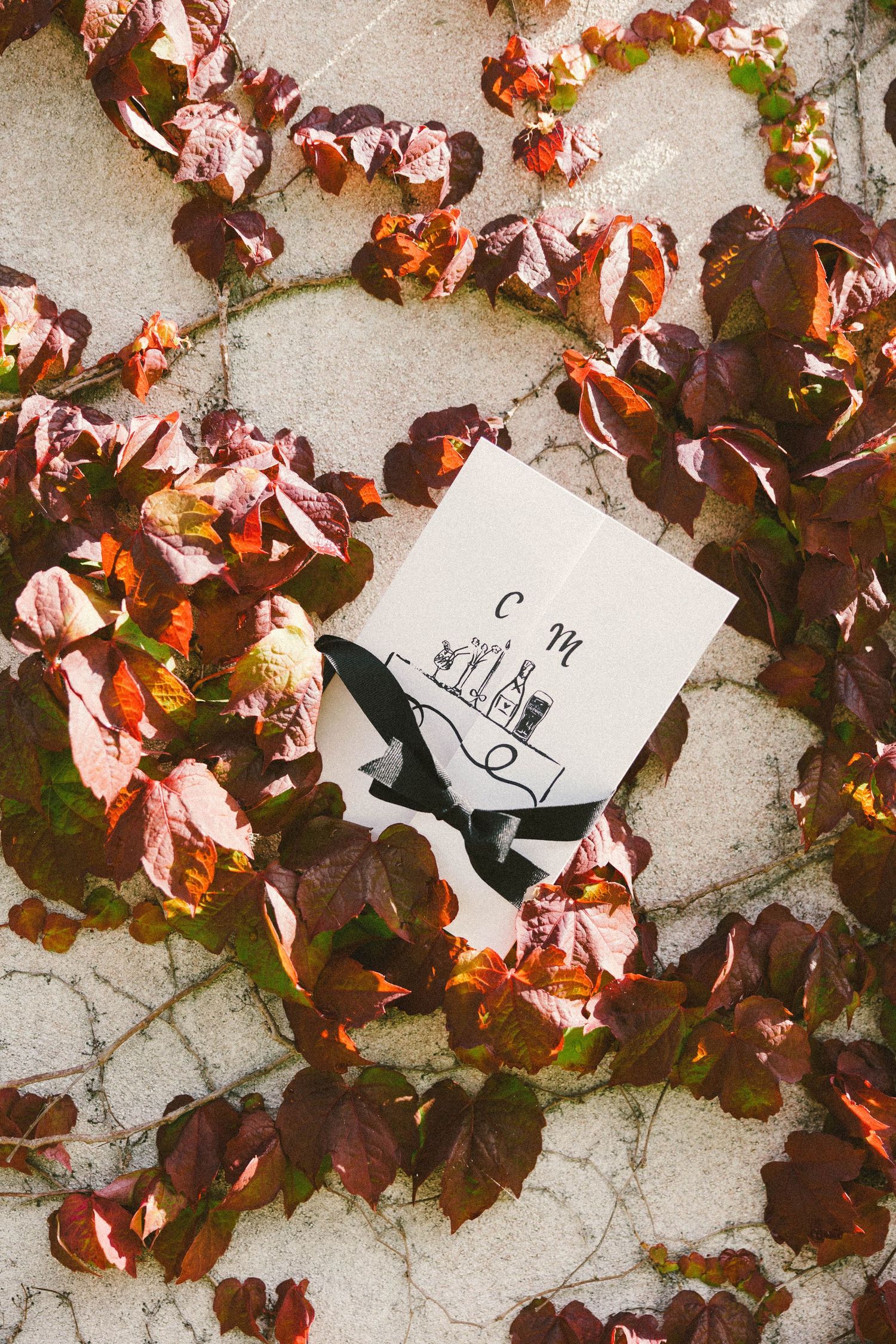 Autumn leaves frame a wedding invitation card with a simple sketch design.
