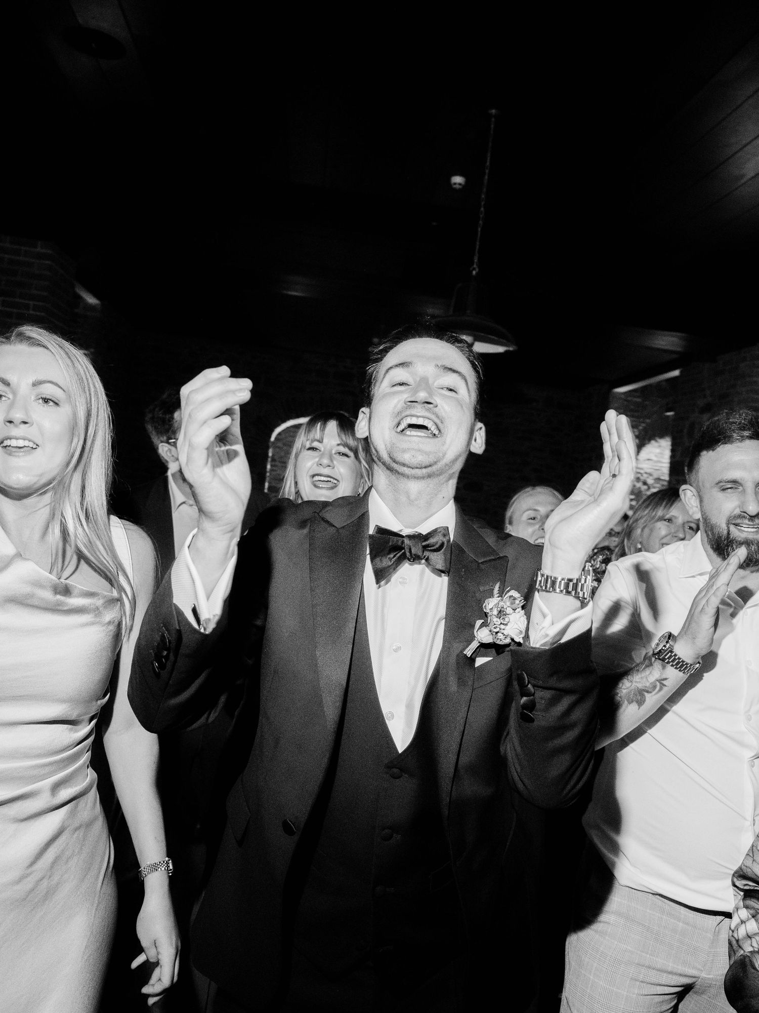 A group of partygoers laughing and having fun in black and white photography.