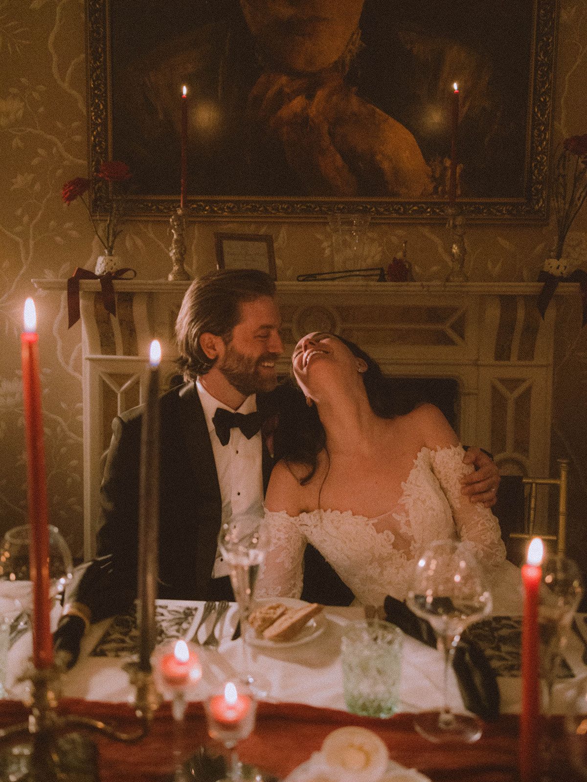 Romantic candlelit dinner scene with couple at elegant table decorated with red candles and vintage decor.