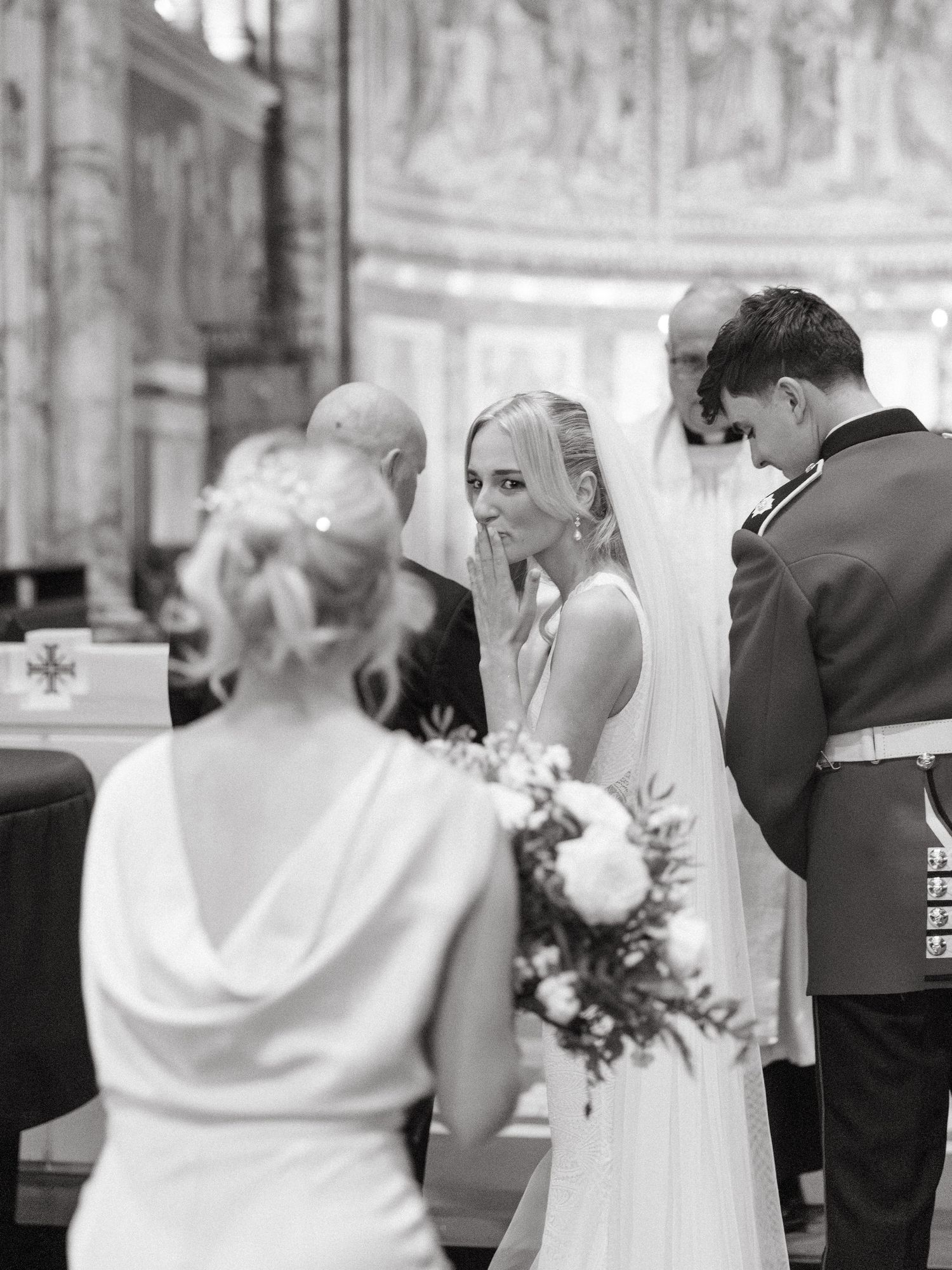 Series of four black and white photos capturing intimate moments during a wedding ceremony in an ornate church.