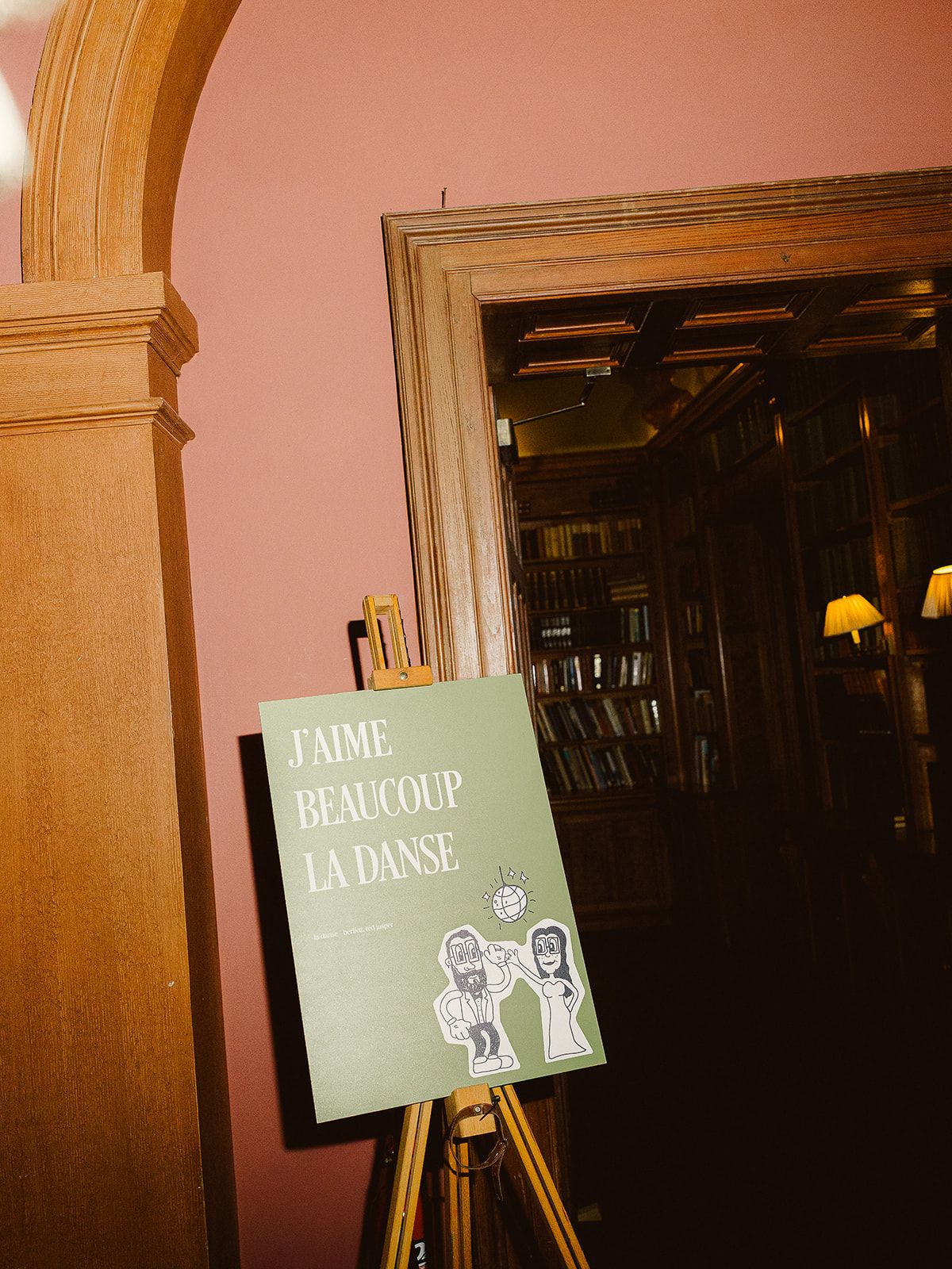 Four vintage-style green signs with cartoon ghost illustrations mounted on wooden walls in dim lighting.