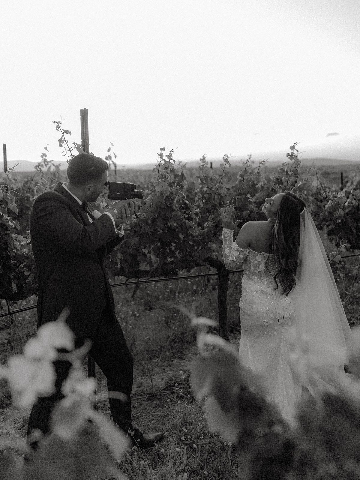 A romantic first look moment between a couple in a vineyard, captured in black and white.