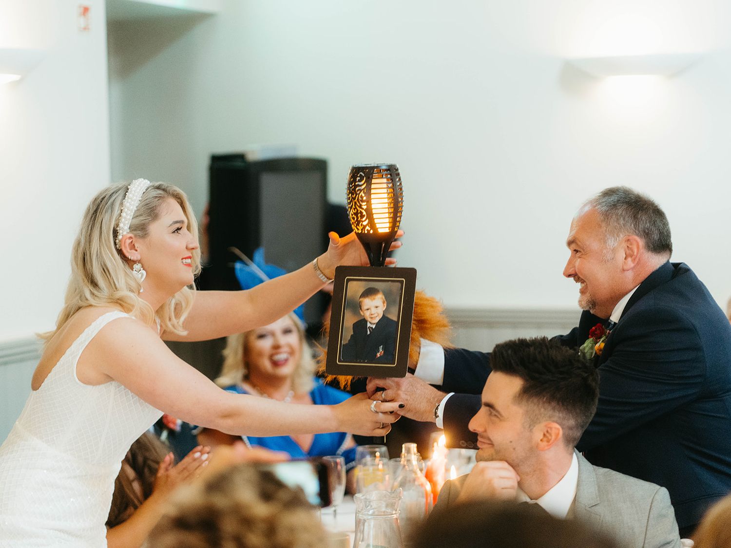 Wedding guests enjoy a candid moment during a reception celebration while raising a drink for a toast.
