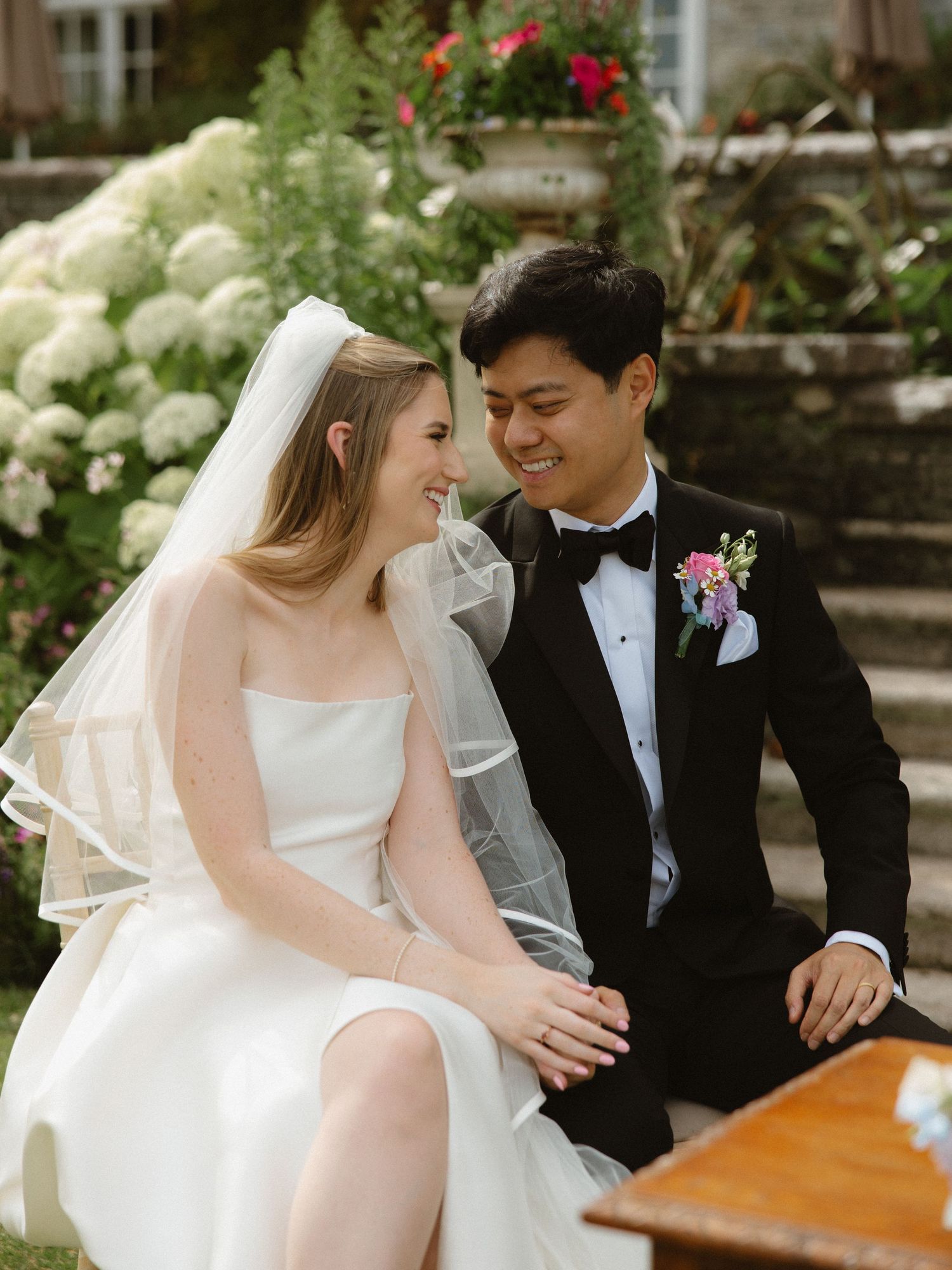 Newlyweds sharing an intimate moment on their wedding day in a garden setting.
