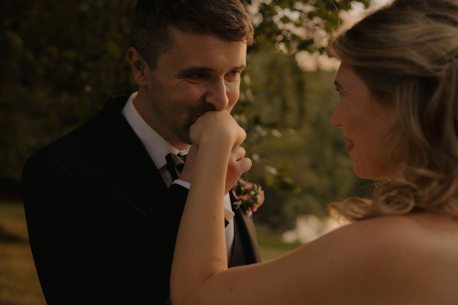 Couple shares intimate moment during outdoor golden hour wedding portraits.