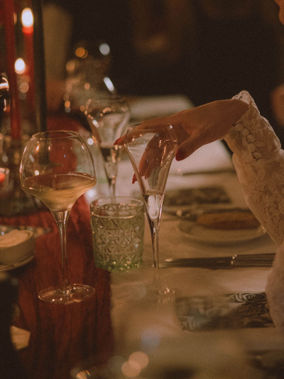 A romantic dinner table setting with glowing candles and wine glasses creating an intimate ambiance.