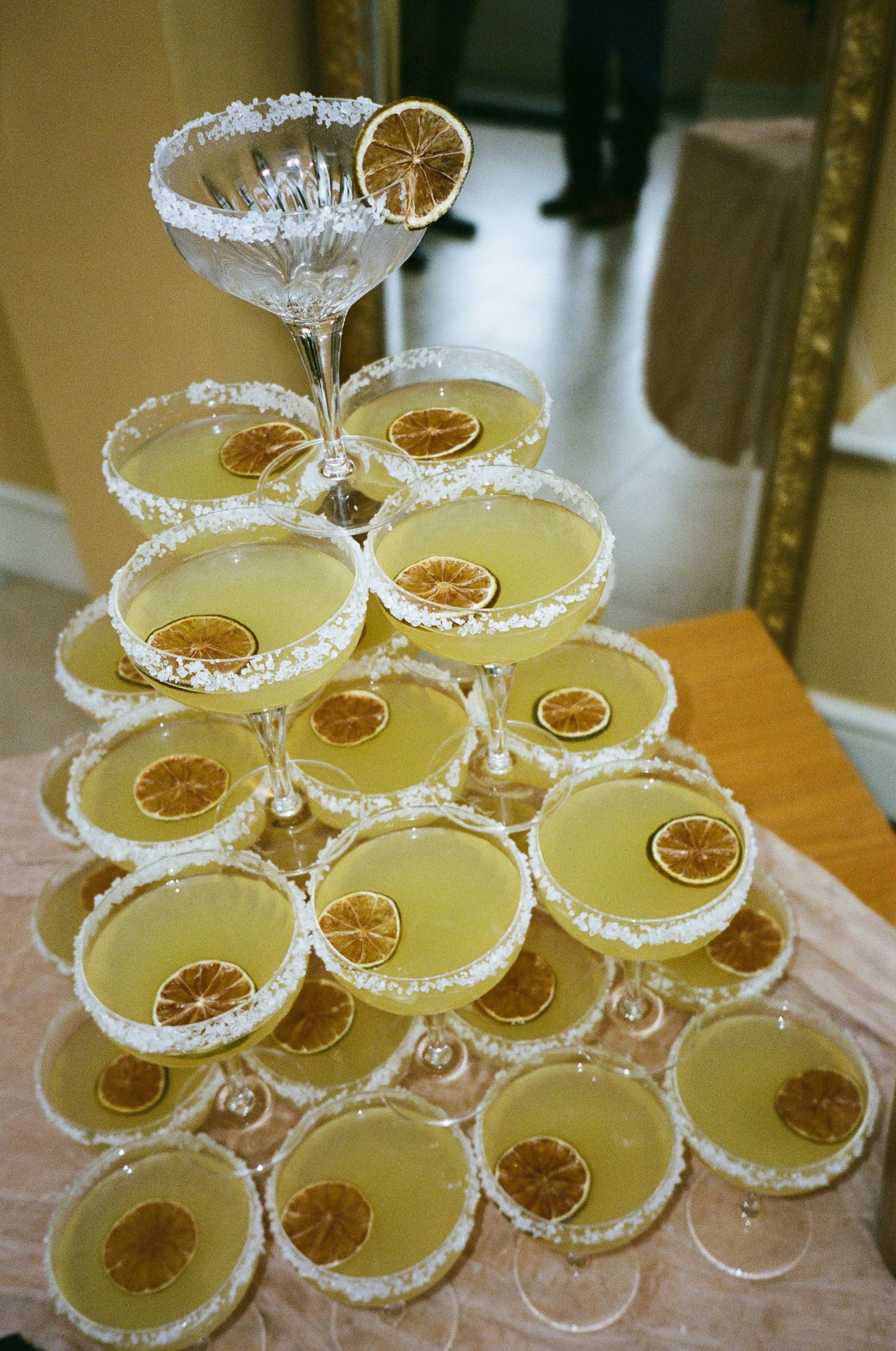 Champagne tower with citrus garnishes arranged in vintage coupe glasses.