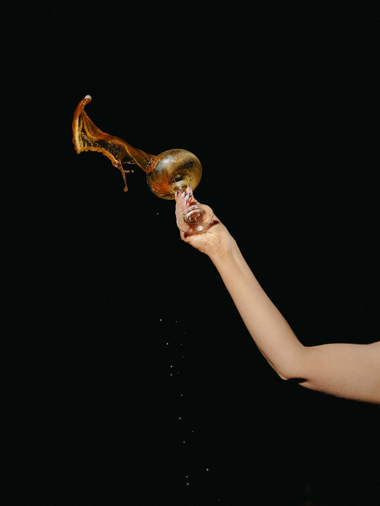 A hand holds an antique brass key against a dark background in a dramatic artistic composition.