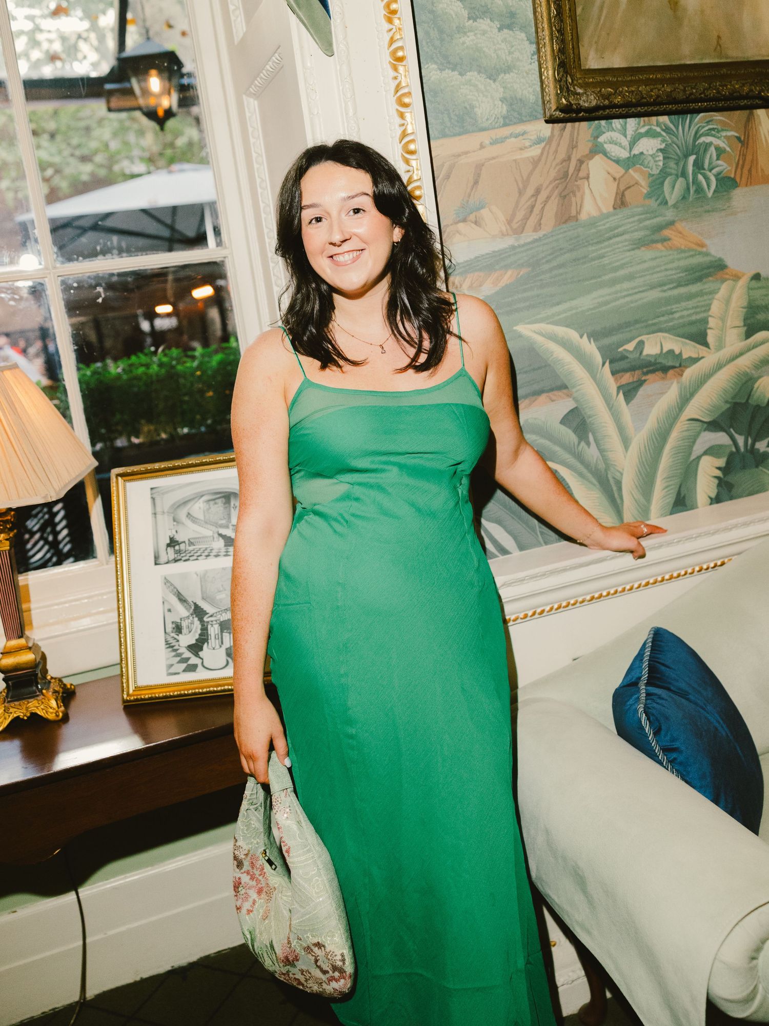 A series of six photos showing someone wearing an emerald green sleeveless dress celebrating at an indoor event.