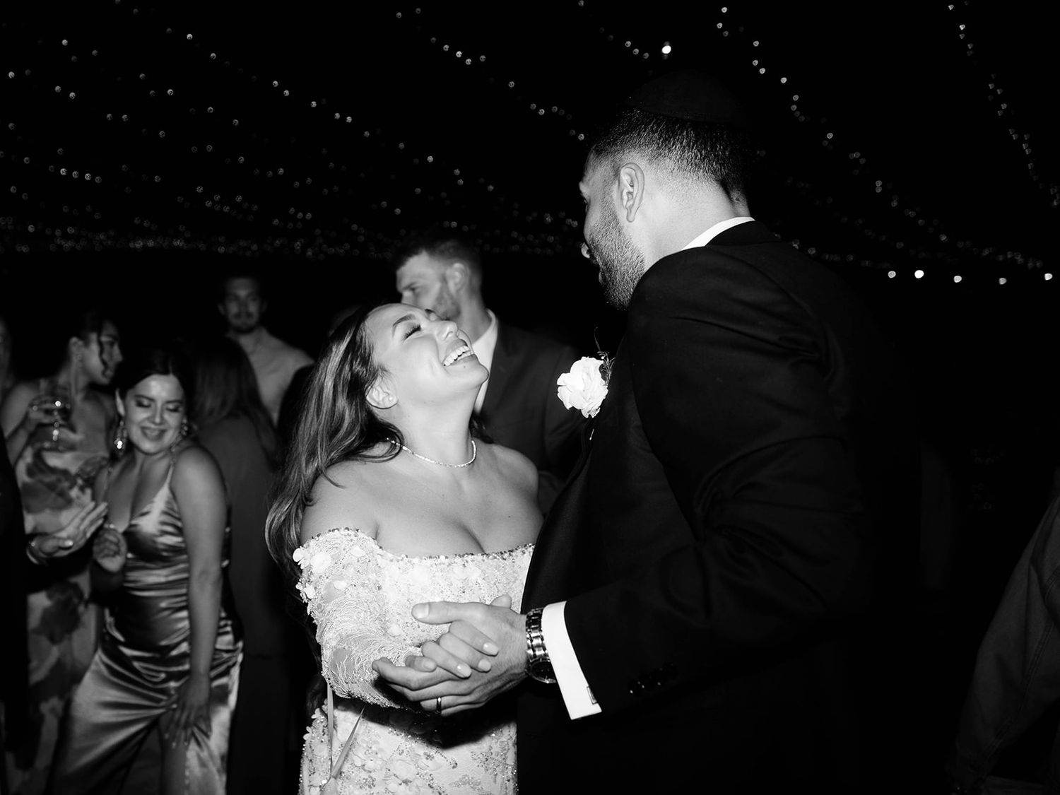 A black and white photograph of a couple sharing a romantic dance moment at their wedding reception.