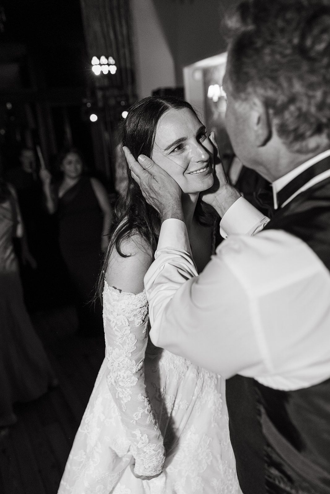 A romantic wedding dance moment captured in black and white showing a couple embracing on the dance floor.