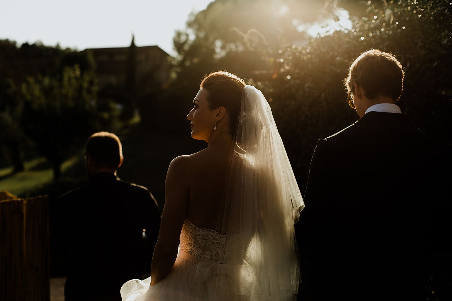 Silhouetted newlyweds share intimate moments in romantic backlit wedding photography sequence.