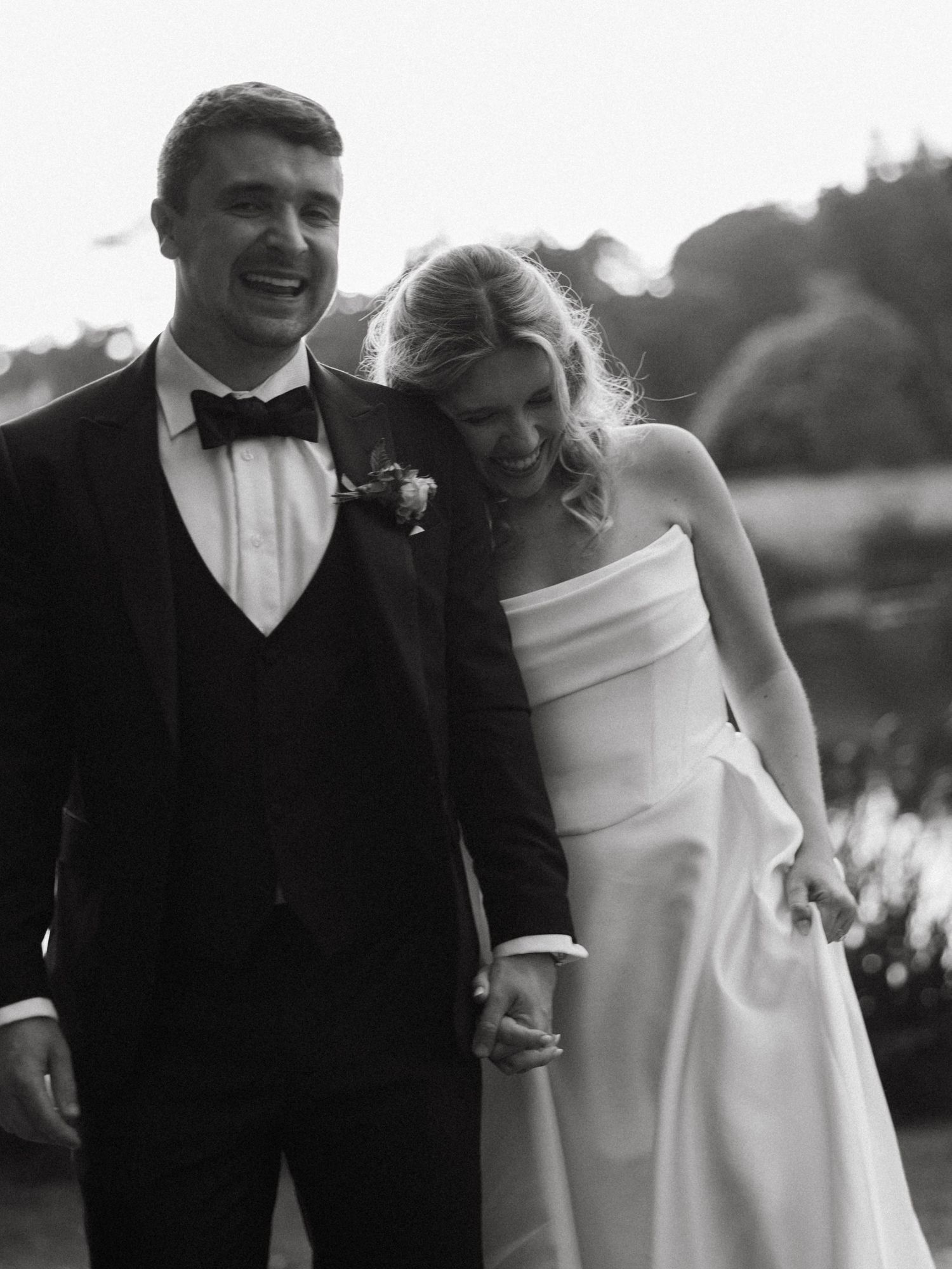 Black and white wedding portraits showing joyful candid moments outdoors.