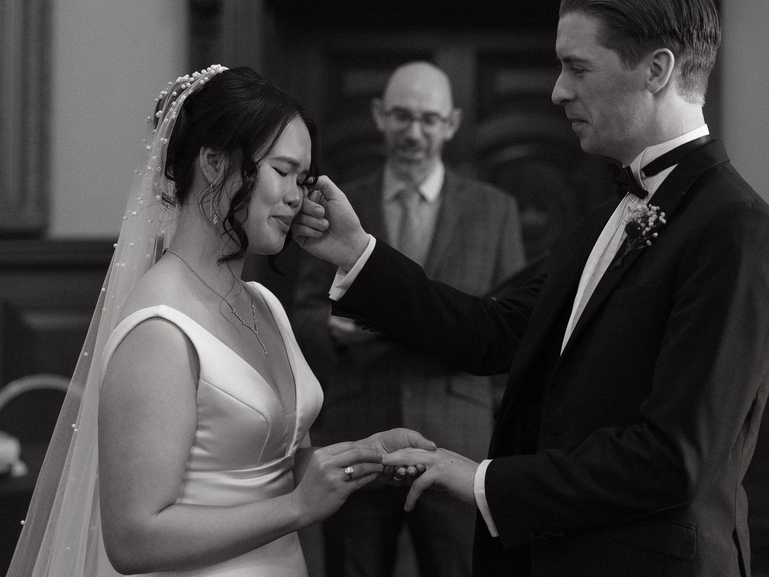 Black and white wedding photos showing tender moments between couples during their ceremony and ring exchange.