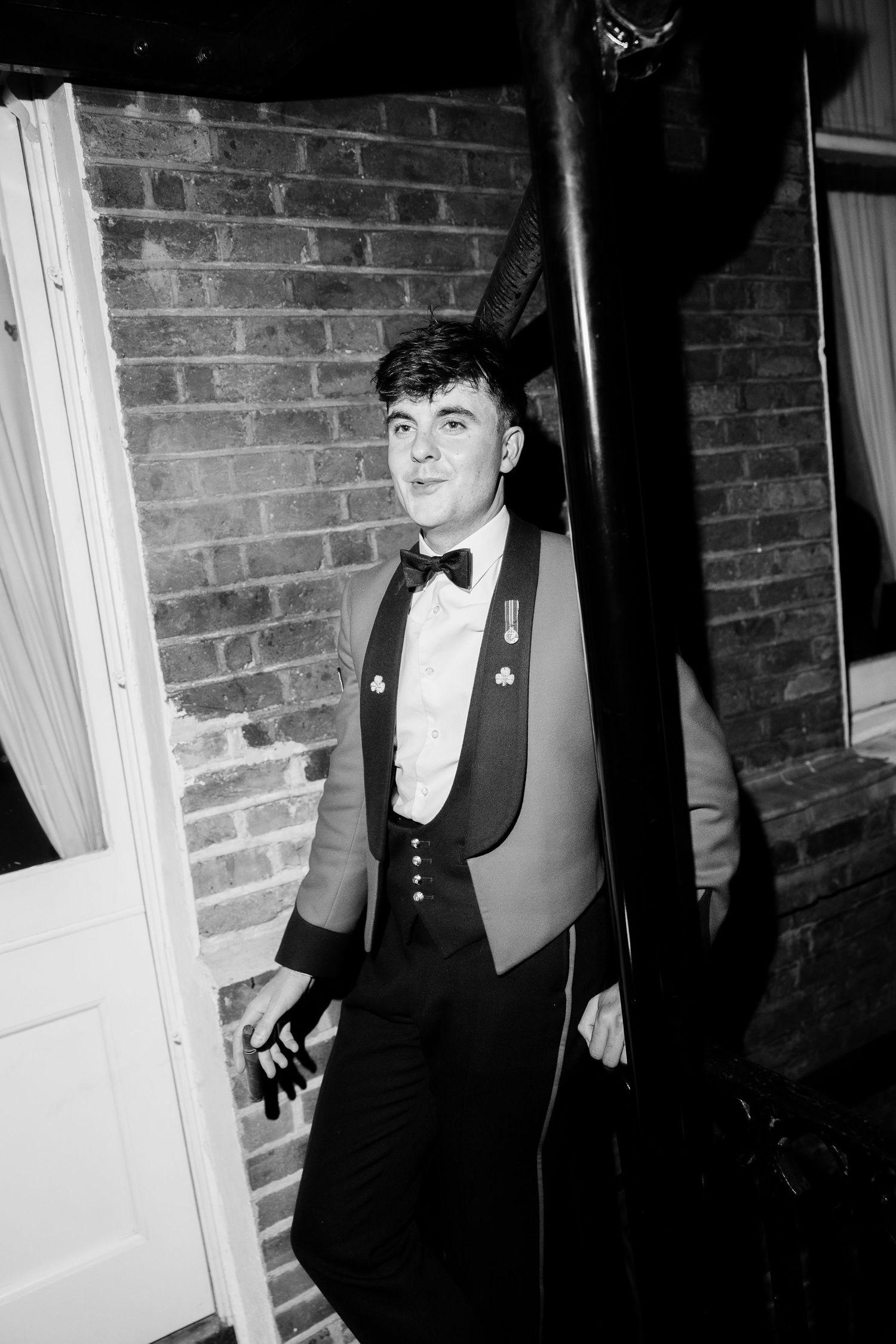 A series of black and white portraits showing a person in formal attire against a brick wall backdrop.