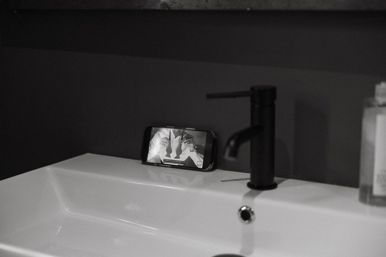 Black and white reflection in bathroom mirror during wedding preparations.